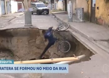 Ciclista cai em cratera na rua durante reportagem ao vivo; assista