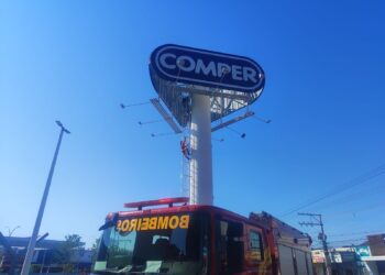 Homem sobe em placa de publicidade na Alzira Santana em Várzea Grande; bombeiros tentam convencê-lo a descer