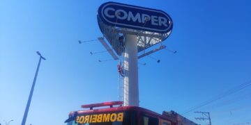 Homem sobe em placa de publicidade na Alzira Santana em Várzea Grande; bombeiros tentam convencê-lo a descer